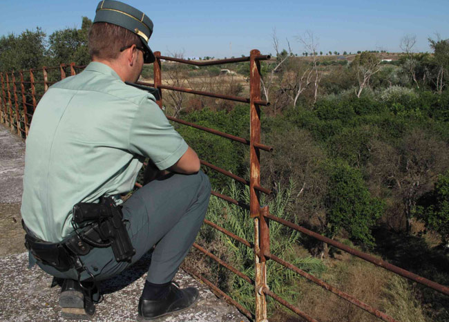 Un agente junto a parte de la barandilla del puente