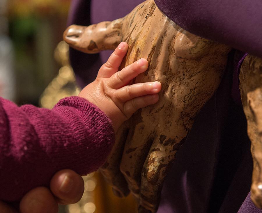 Un niño acaricia la mano al Gran Poder/ Hermandad del Gran Poder