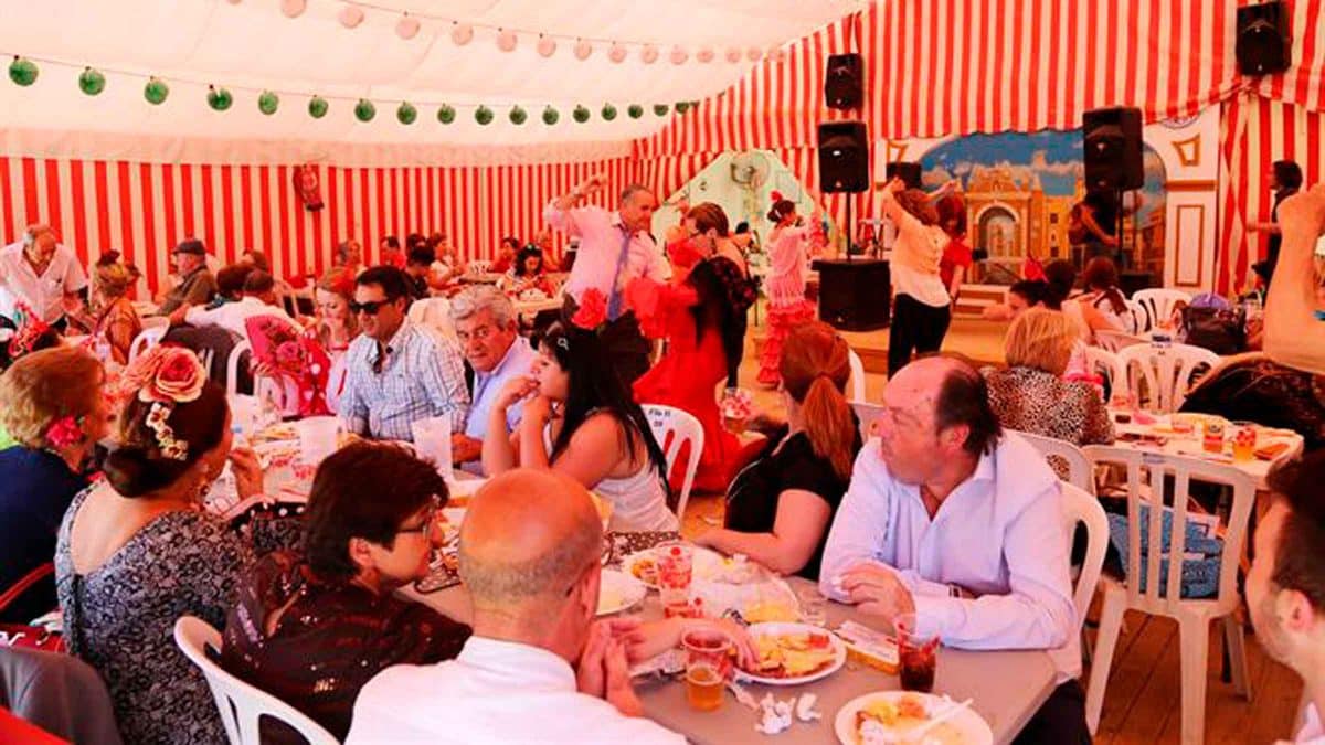 Personas disfrutando en una caseta en la Feria de Sevilla.- Archivo