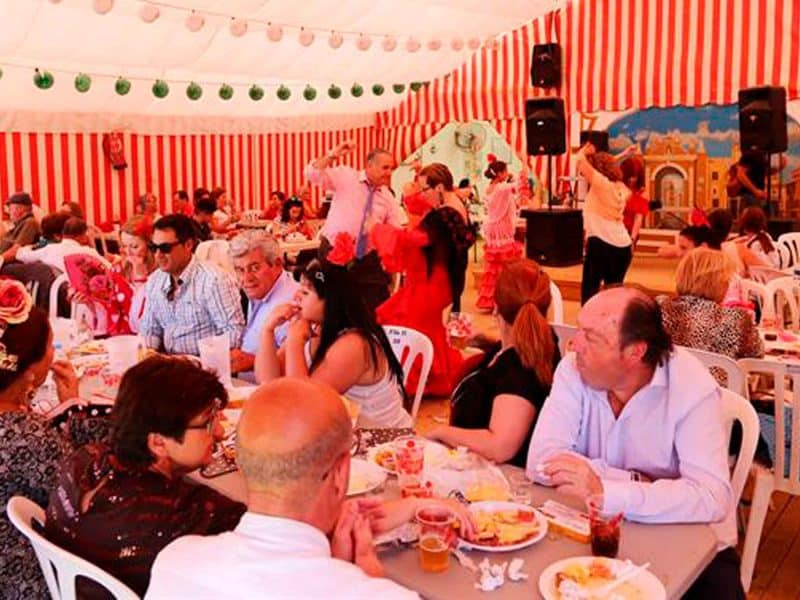 Personas disfrutando en una caseta en la Feria de Sevilla.- Archivo