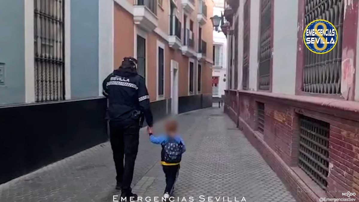El agente de policía local en cuestión, de la mano con el niño