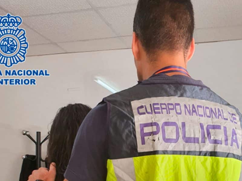 Un agente de Policía Nacional escolta a una de las detenidas