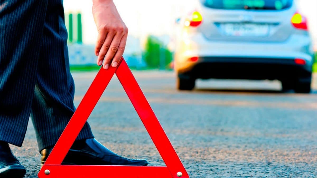 Imagen de recurso de un conductor colocando un triángulo de emergencia