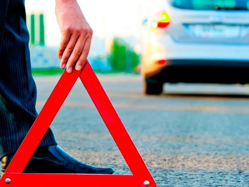 Imagen de recurso de un conductor colocando un triángulo de emergencia