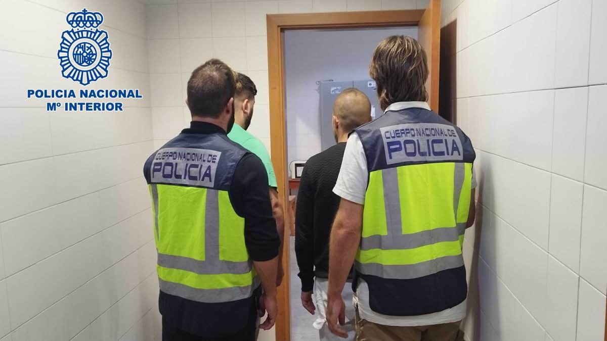 Los detenidos escoltados por dos agentes de policía