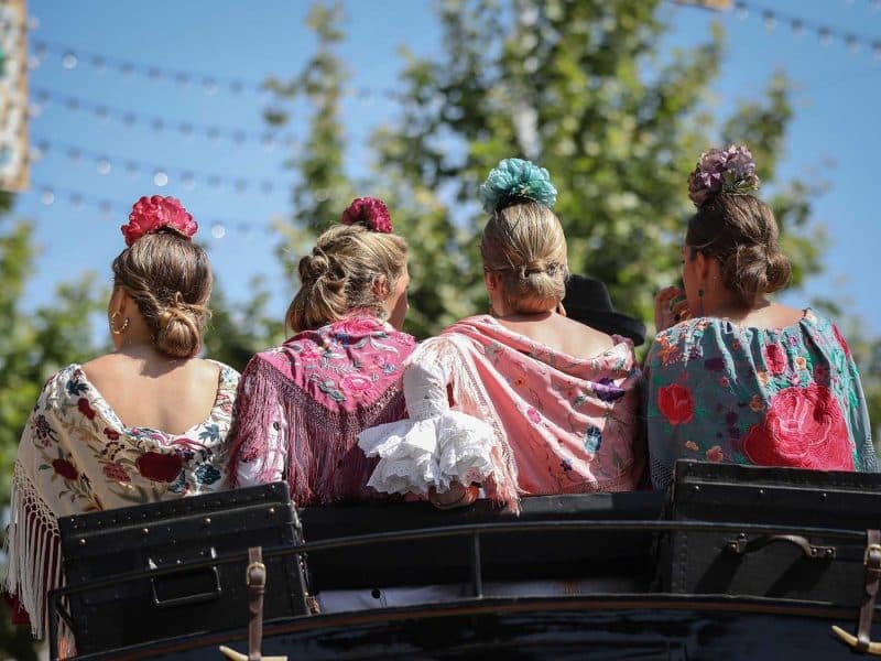 Cuatro mujeres sobre una carroza tirada por caballos