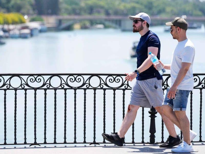 Un joven porta una botella de agua para sofocar el calor en Sevilla en una imagen de archivo - Joaquin Corchero - Europa Press