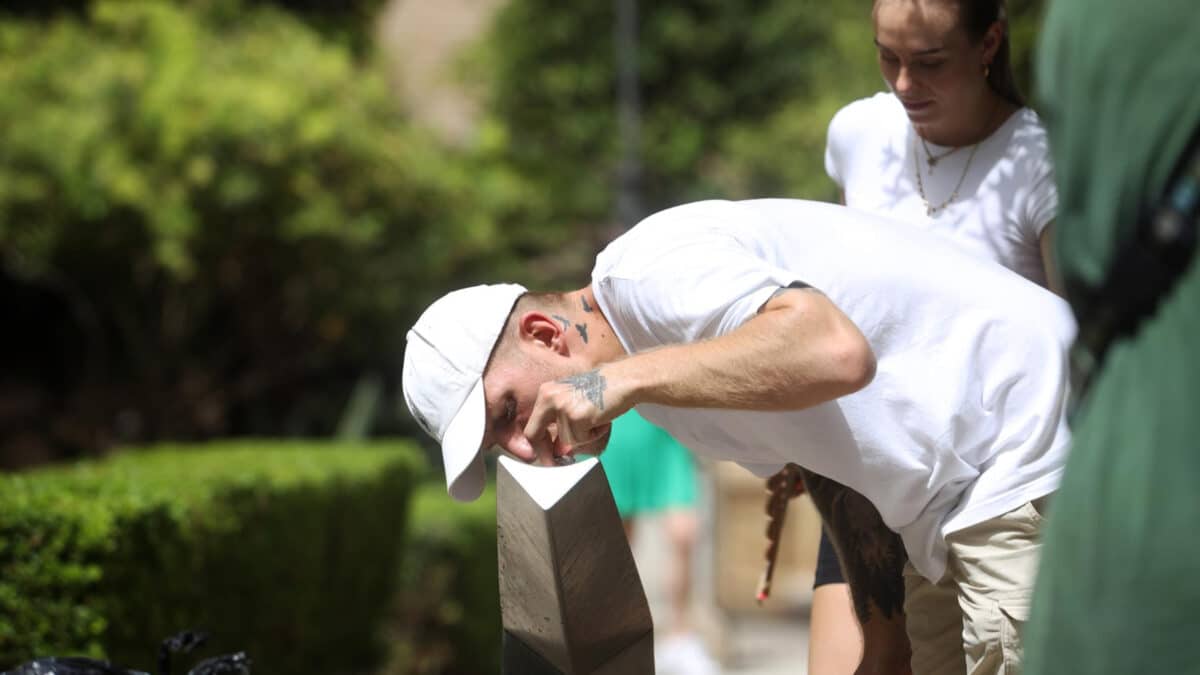 Archivo - Un hombre bebe agua de una fuente para combatir el calor. - Álex Zea - Europa Press - Archivo