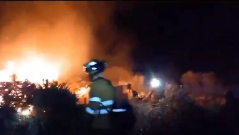 Imagen de bomberos durante la extinción del incendio forestal declarado en el paraje de El Palmitero, en Cantillana. Plan Infoca