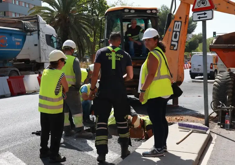 Un bombero y trabajadores de la obra supervisan la zona de la Avenida de las Ciencias en Sevilla Este, donde se ha producido un escape de gas. - Rocío Ruz - Europa Press