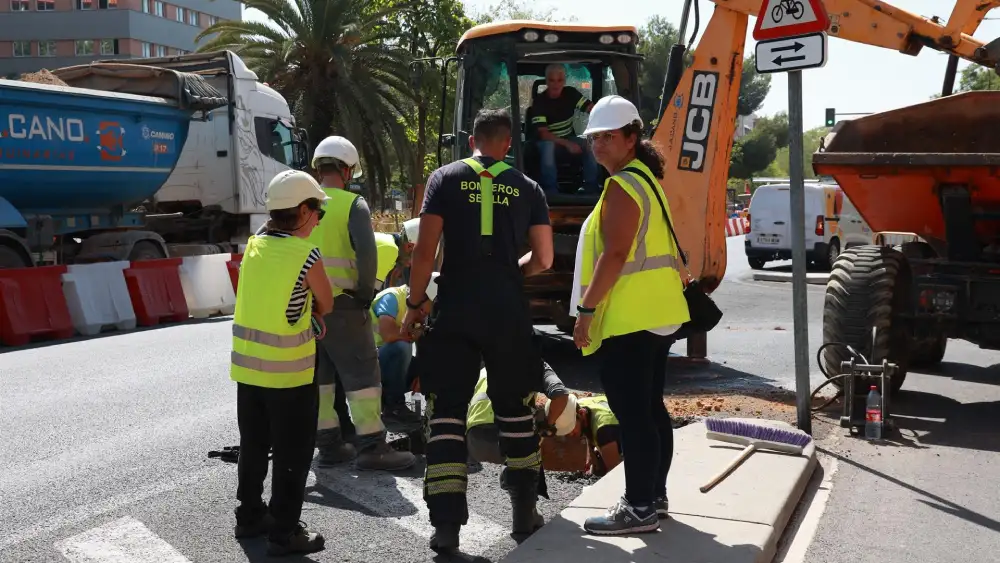 Un bombero y trabajadores de la obra supervisan la zona de la Avenida de las Ciencias en Sevilla Este, donde se ha producido un escape de gas. - Rocío Ruz - Europa Press