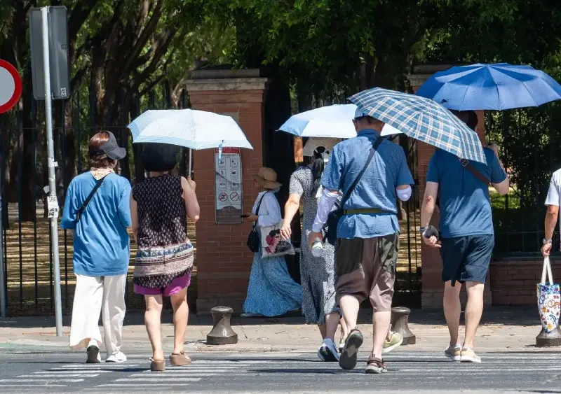 Imágenes de personas caminando con sombrillas por las calles de la capital hispalense (imagen de archivo). - Francisco J. Olmo - Europa Press