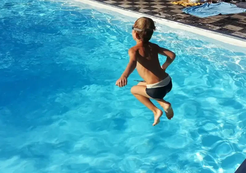 Imagen de archivo de un niño saltando a una piscina. EP