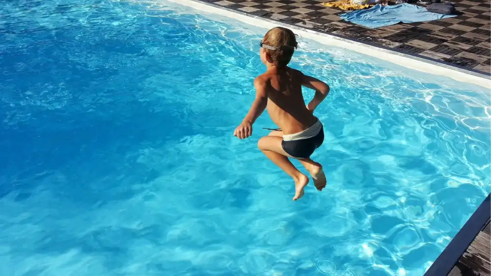 Imagen de archivo de un niño saltando a una piscina. EP