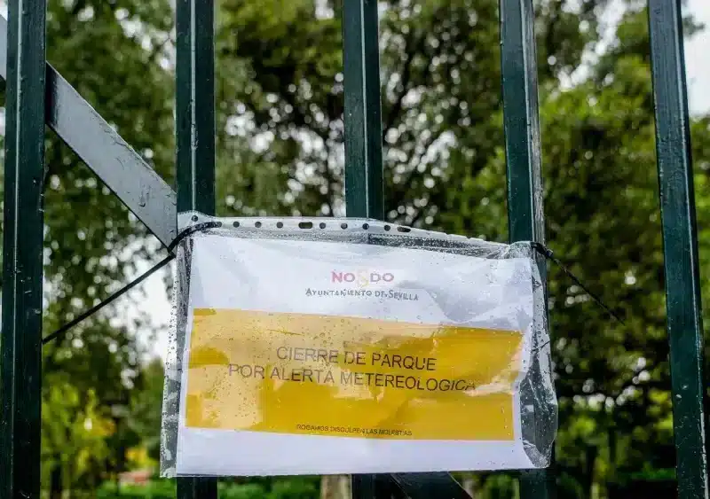 Archivo - Cartel en una reja de entrada al Parque de María Luisa que indica el cierre por alerta meteorológica. Imagen de archivo. - Eduardo Briones - Europa Press - Archivo