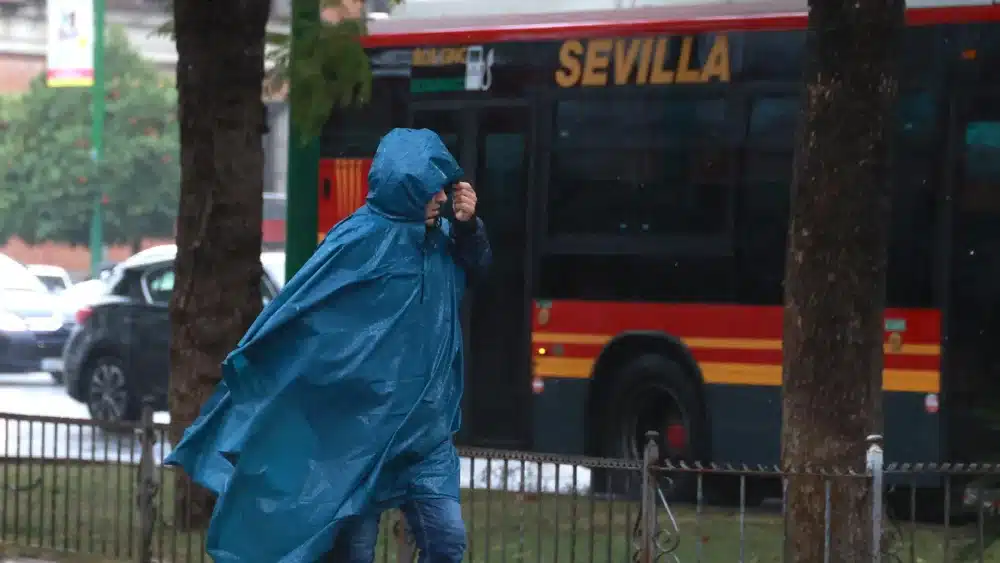Archivo - Una persona se protege de la lluvia con su impermeable. Imagen de archivo. - Rocío Ruz - Europa Press - Archivo