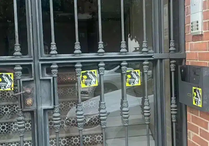 Pegatinas de la Macarena con la Rosa de Oro en un portal de Triana. A Pulso