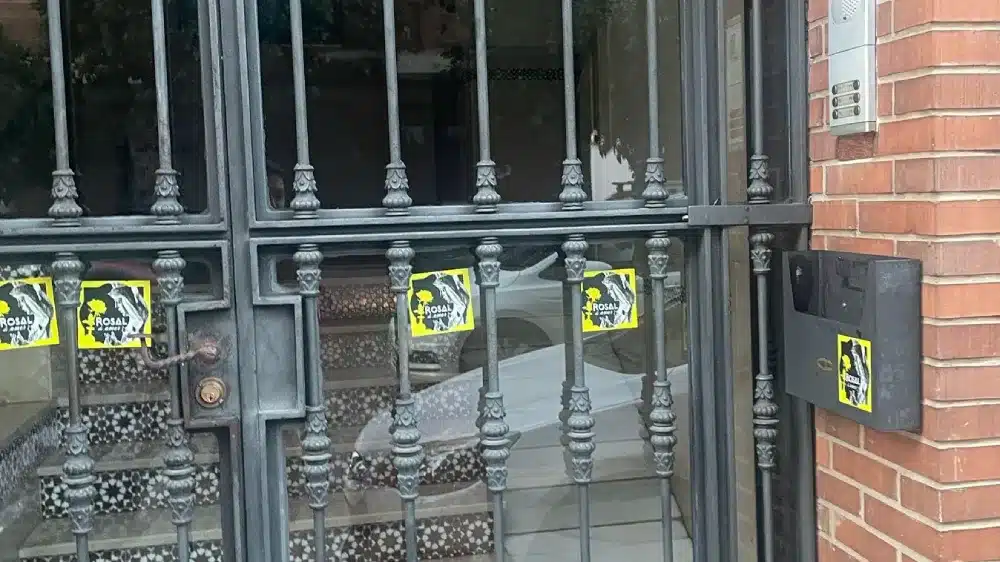 Pegatinas de la Macarena con la Rosa de Oro en un portal de Triana. A Pulso