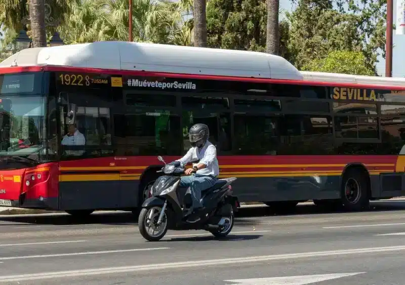 Archivo - Una motocicleta circula junto a un autobús de Tussam en el Paseo de Colón. - FRANCISCO J. OLMO / EUROPA PRESS - Archivo