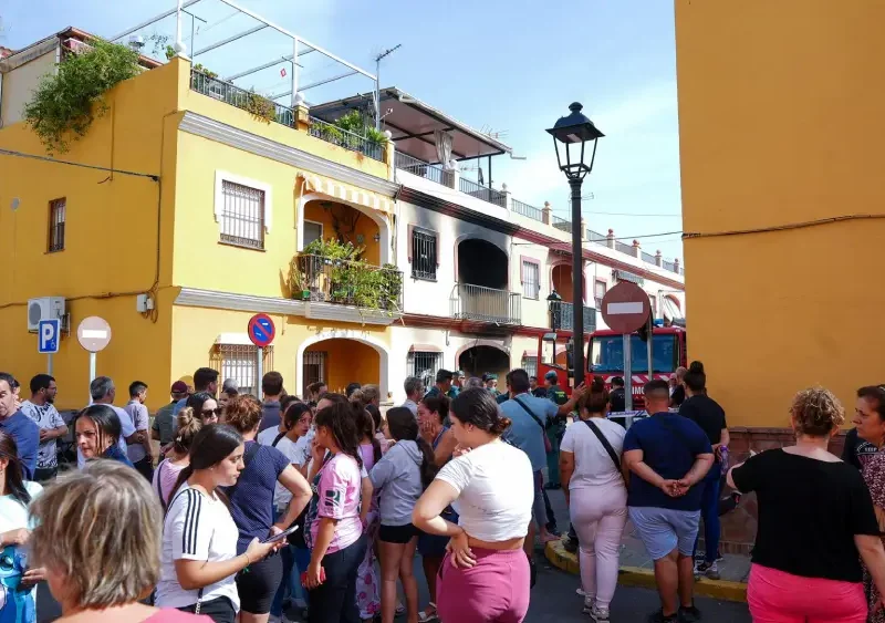 Vecinos se agolpan junto a la vivienda incendiada este domingo en Guillena (Sevilla). - Francisco J. Olmo - Europa Press