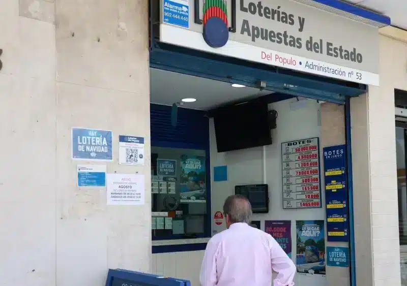 Archivo - Una persona se dispone a adquierir un boleto en una Administración de Loterias, en el centro de Sevilla. Imagen de archivo. - ROCÍO RUZ / EUROPA PRESS - Archivo