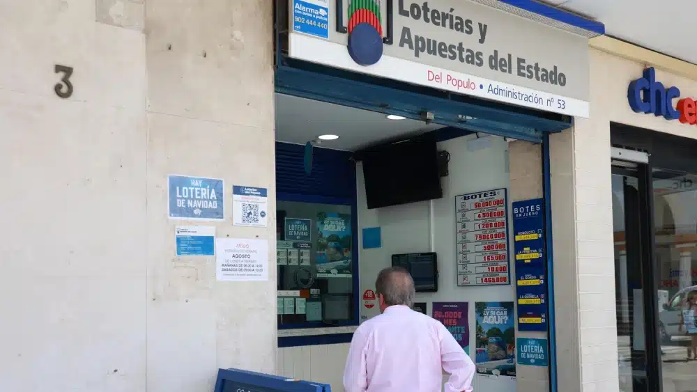 Archivo - Una persona se dispone a adquierir un boleto en una Administración de Loterias, en el centro de Sevilla. Imagen de archivo. - ROCÍO RUZ / EUROPA PRESS - Archivo