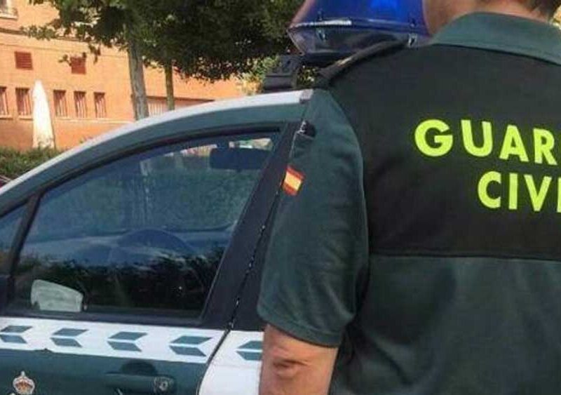 Agente de la Guardia Civil ante un coche patrulla - Guardia Civil