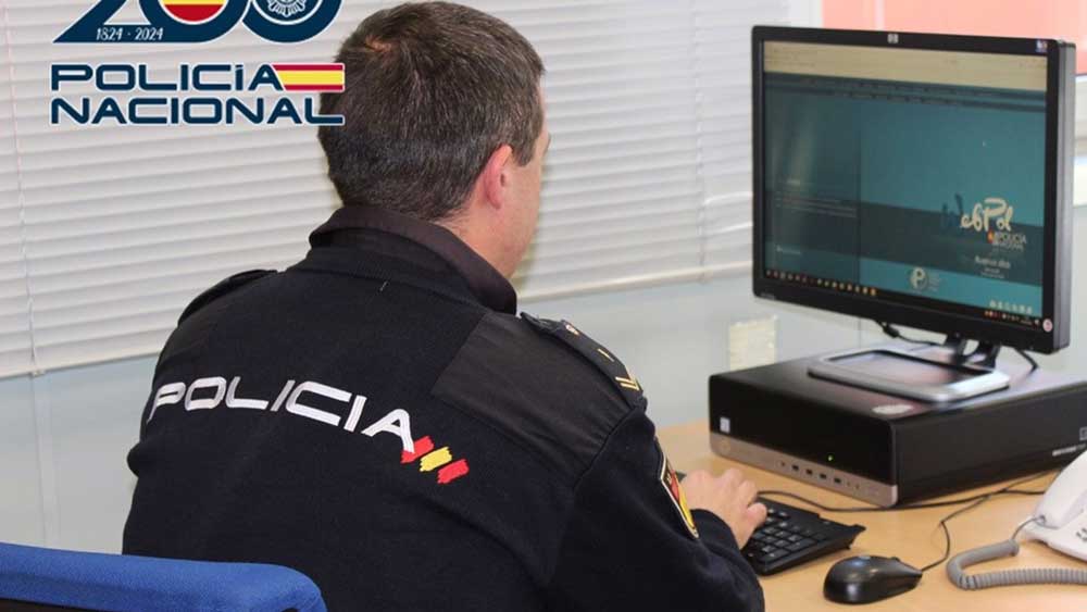 Imagen de un agente haciendo gestiones con un ordenador - Policía Nacional