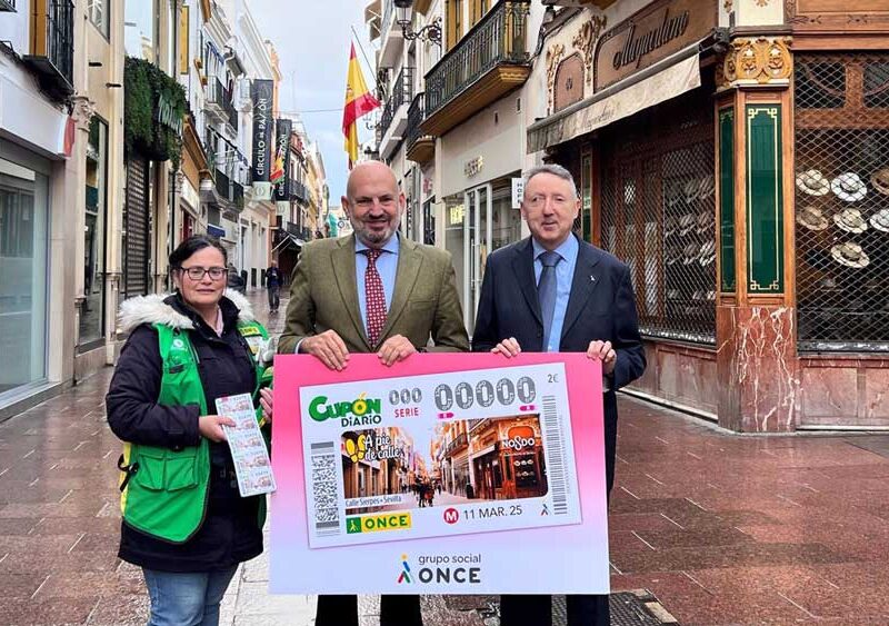 Manuel Alés, en el centro, junto al delegado territorial de la ONCE y una vendedora, con el cupón dedicado a la calle Sierpes. - ONCE