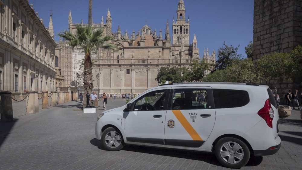 Un taxi adaptado para personas de movilidad reducida circulando cerca de la Catedral. - Plataforma Eurotaxi Sevilla