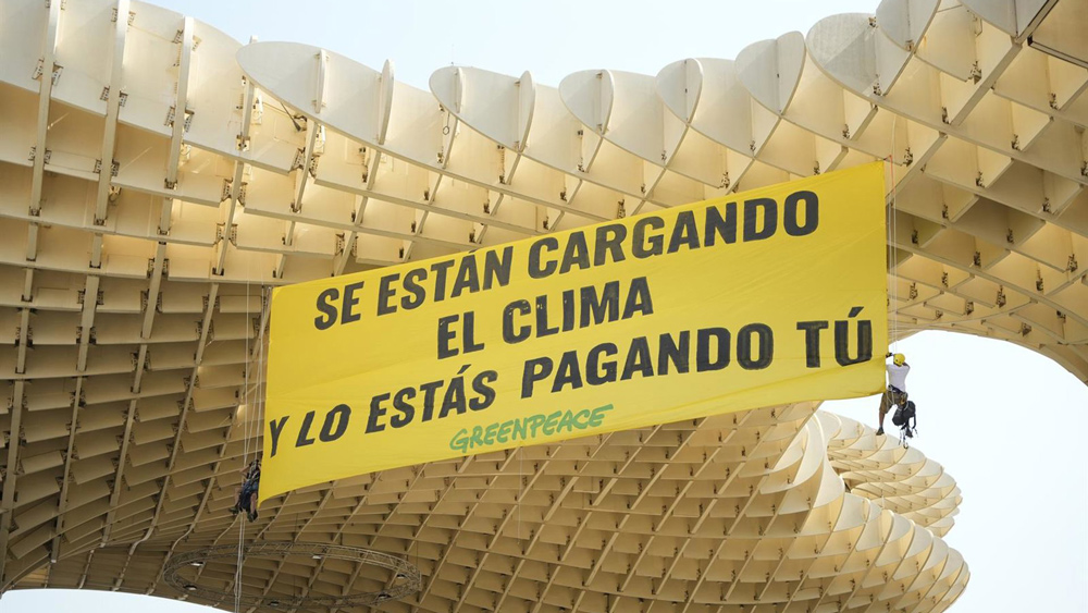 Cartel reivindicativo desplegado por Greenpeace en defensa del clima. - Joaquín Corchero / Europa Press