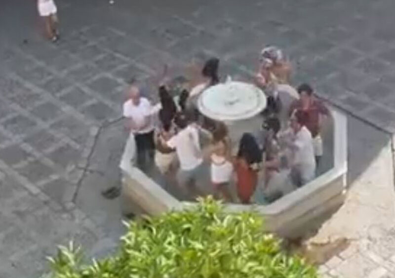 Los turistas bailando en una fuente del barrio de Santa Cruz. - @jesusvermu vía X