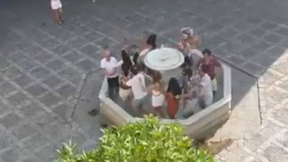 Los turistas bailando en una fuente del barrio de Santa Cruz. - @jesusvermu vía X