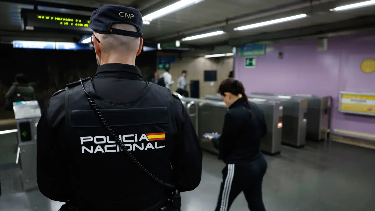Agente de la Policía Nacional junto a los tornos del metro