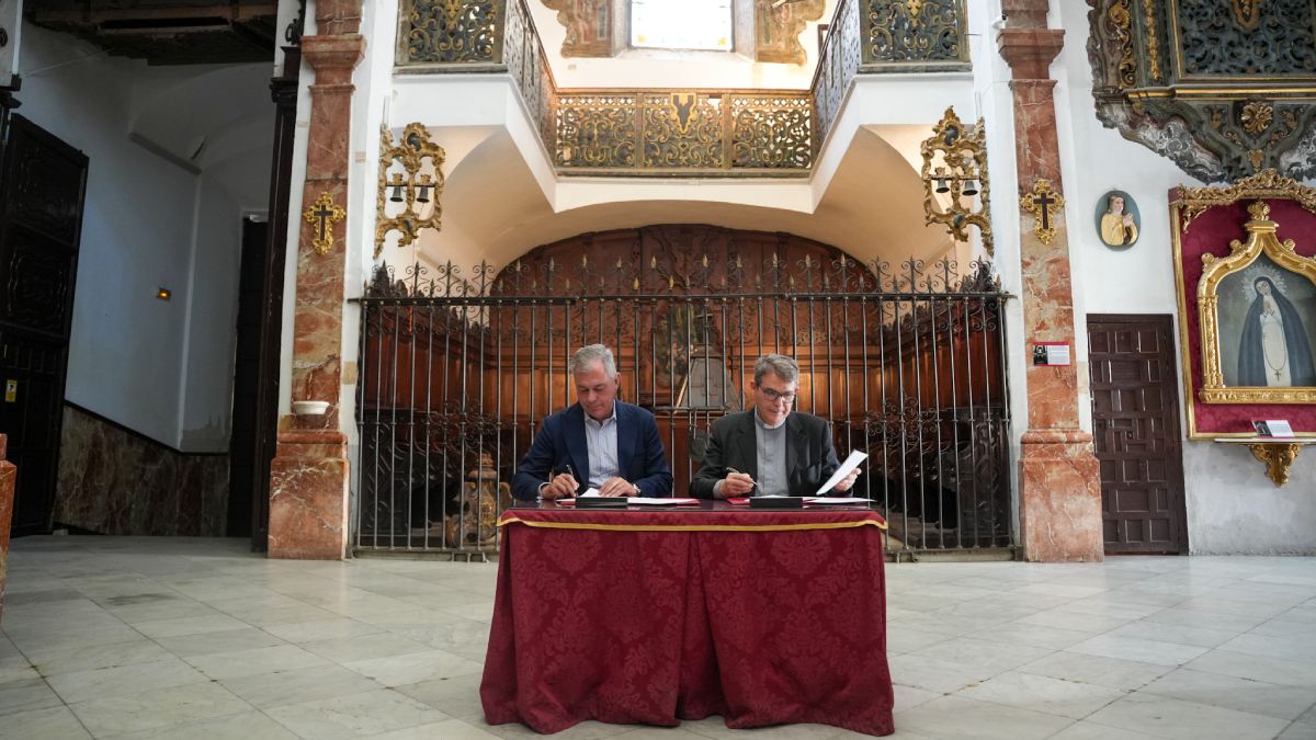 Sanz y el párroco de San Nicolás y Santa María la Blanca en la firma del convenio