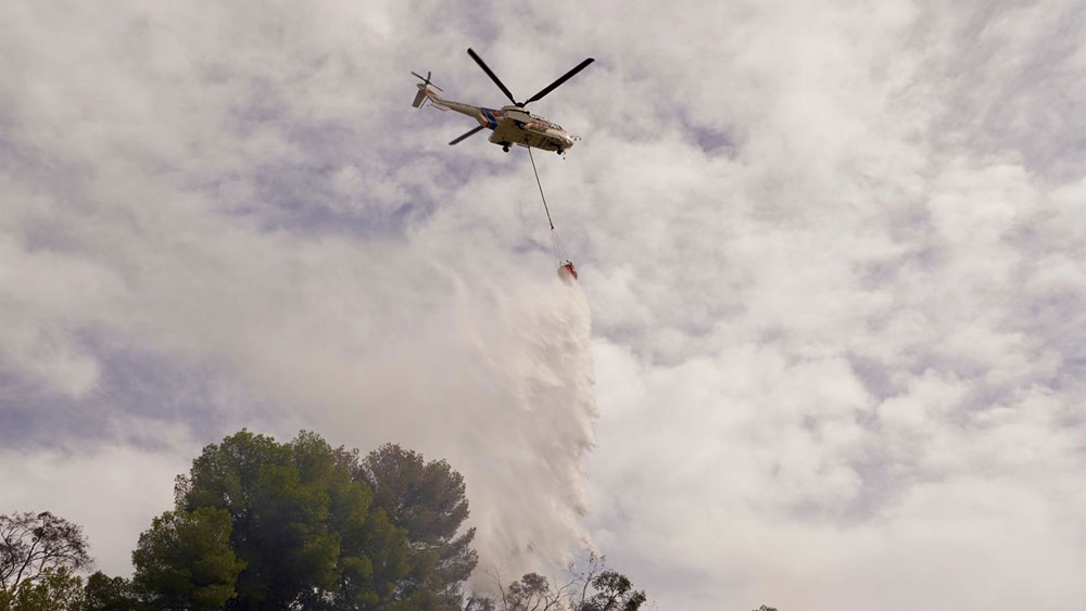 Un helicóptero del Infoca arroja agua sobre un incendio, en imagen de recurso. - Álex Zea / Europa Press