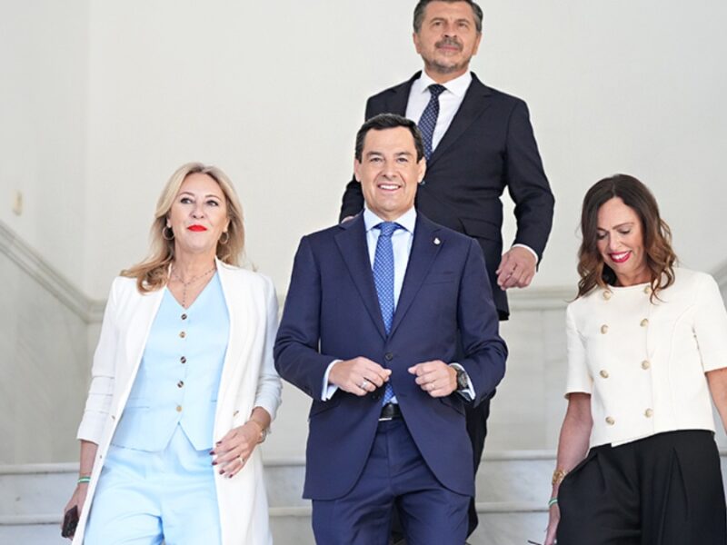 Juanma Moreno, secundado por las consejeras de Economía y de Fomento, Carolina España y Rocío Díaz, en los pasillos del Parlamento andaluz.